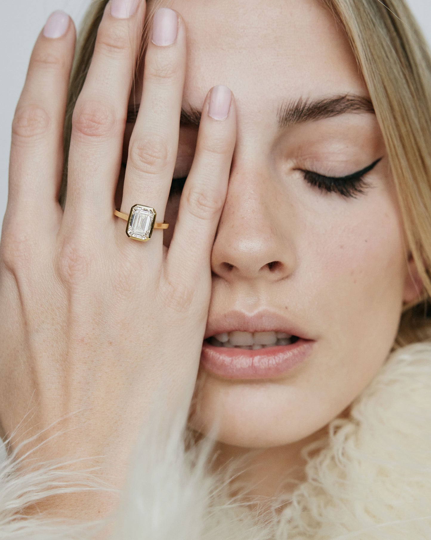 Model wearing rectangle shaped diamond on gold band