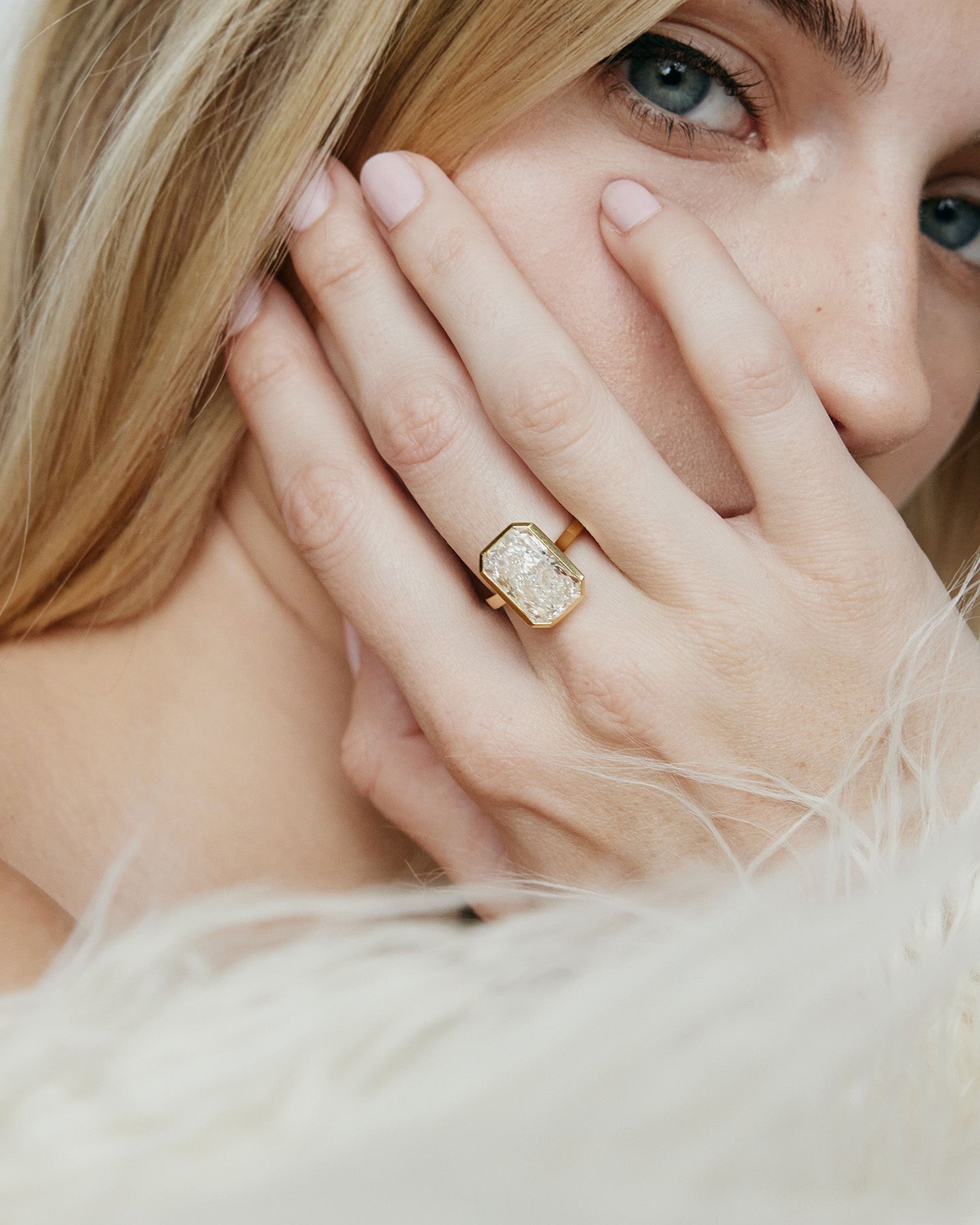 Model wearing rectangle shaped diamond on a gold band