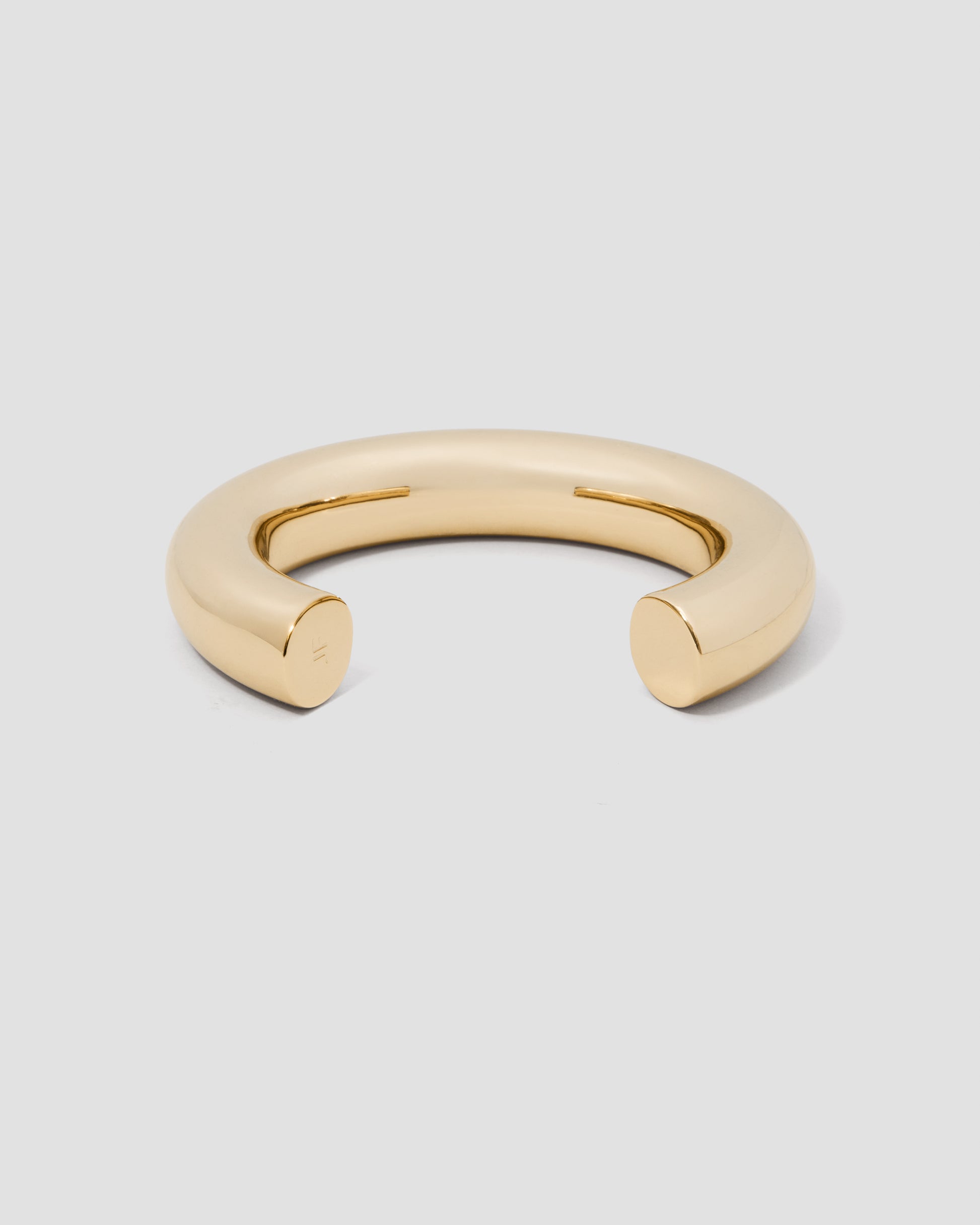 Gold bracelet on a light gray background