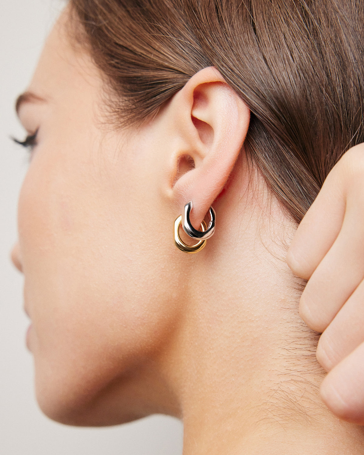 Model wearing huggies together one ear.
