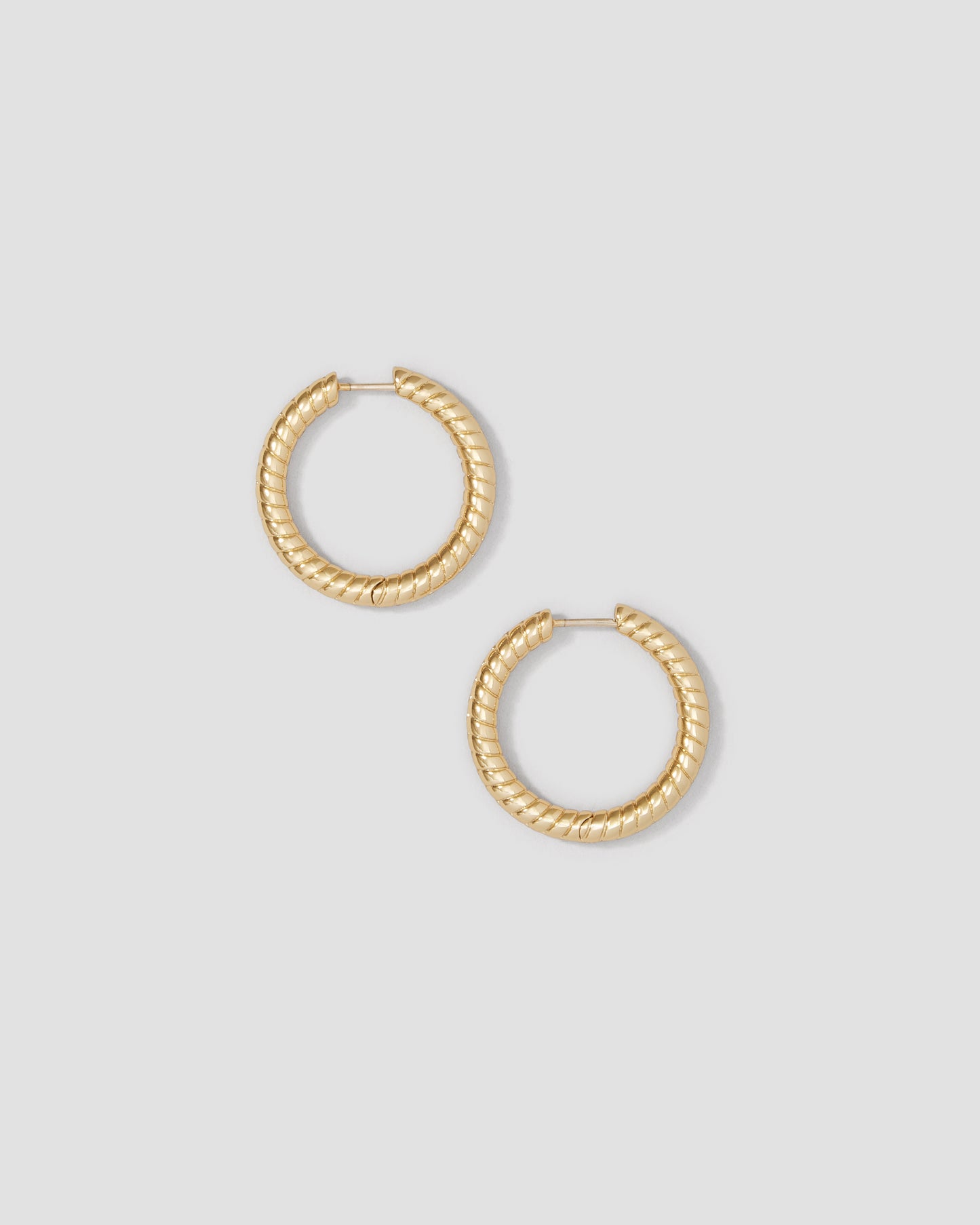 Gold hoop earrings on a light gray background