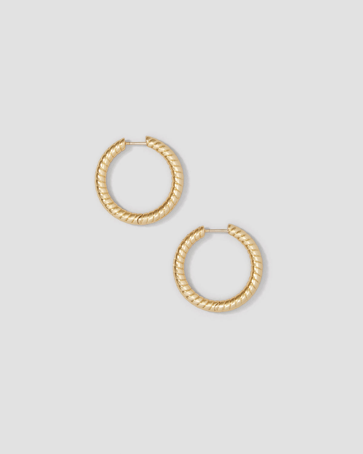 Gold hoop earrings on a light gray background