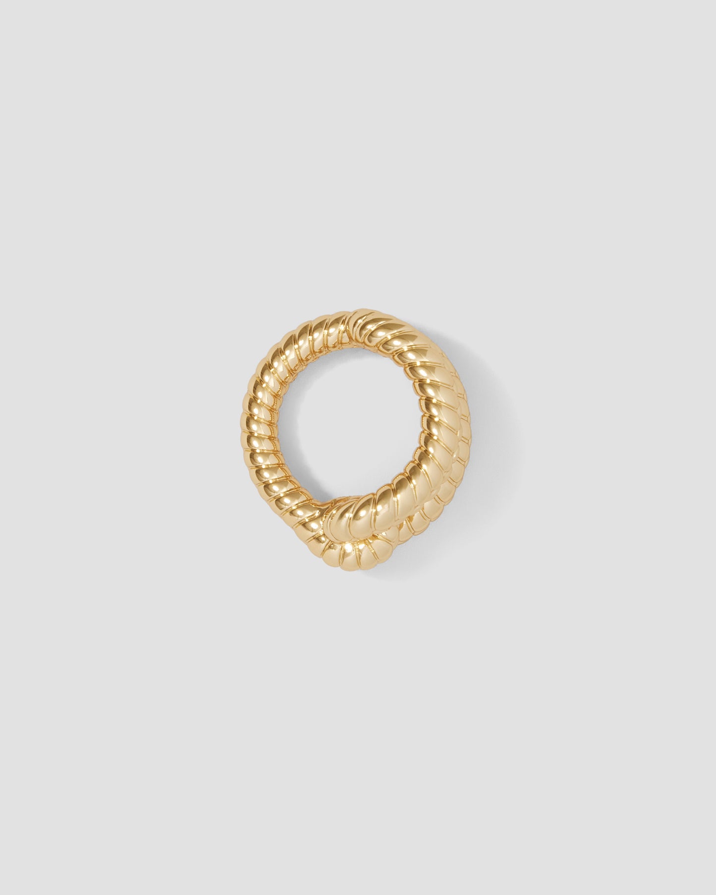 Gold ring with a textured design on a light gray background