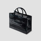 Black handbag with 'Jennifer Fisher' branding on a light gray background
