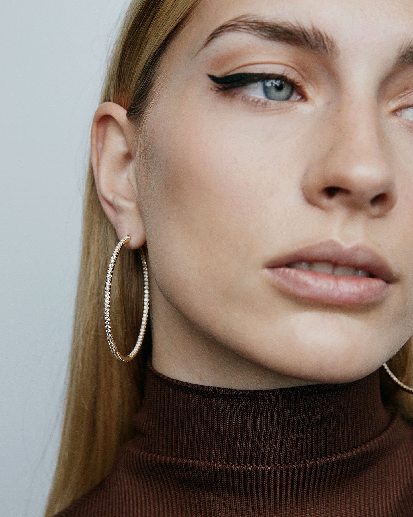 2" diamond hoops on model wearing brown top