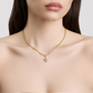 Gold necklace with a star pendant on a model against a neutral background