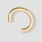 Gold hoop earring on a light gray background