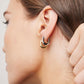 Model wearing huggies together one ear. 