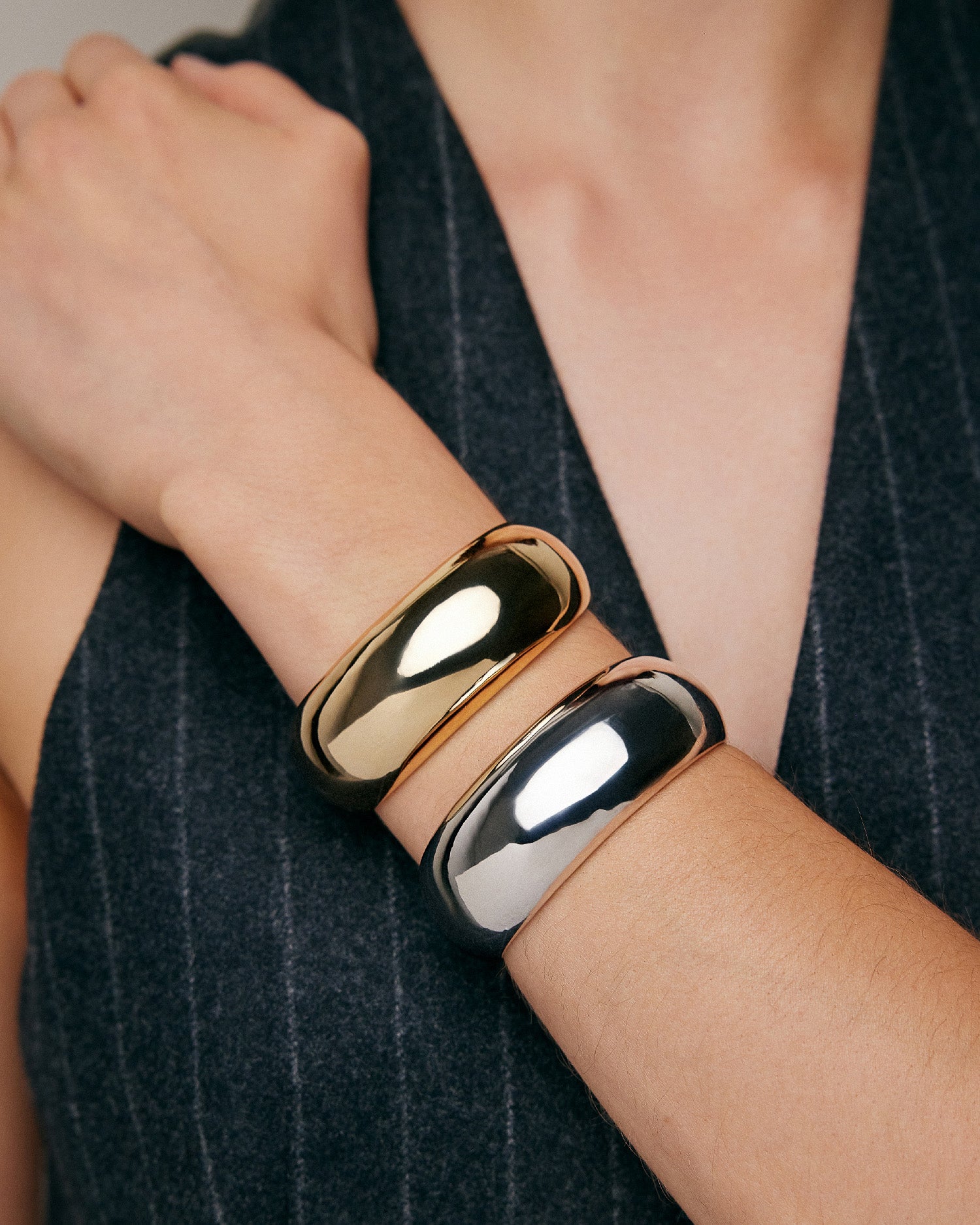 Model wearing gold and silver cuff. 