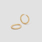 Gold hoop earrings on a light gray background