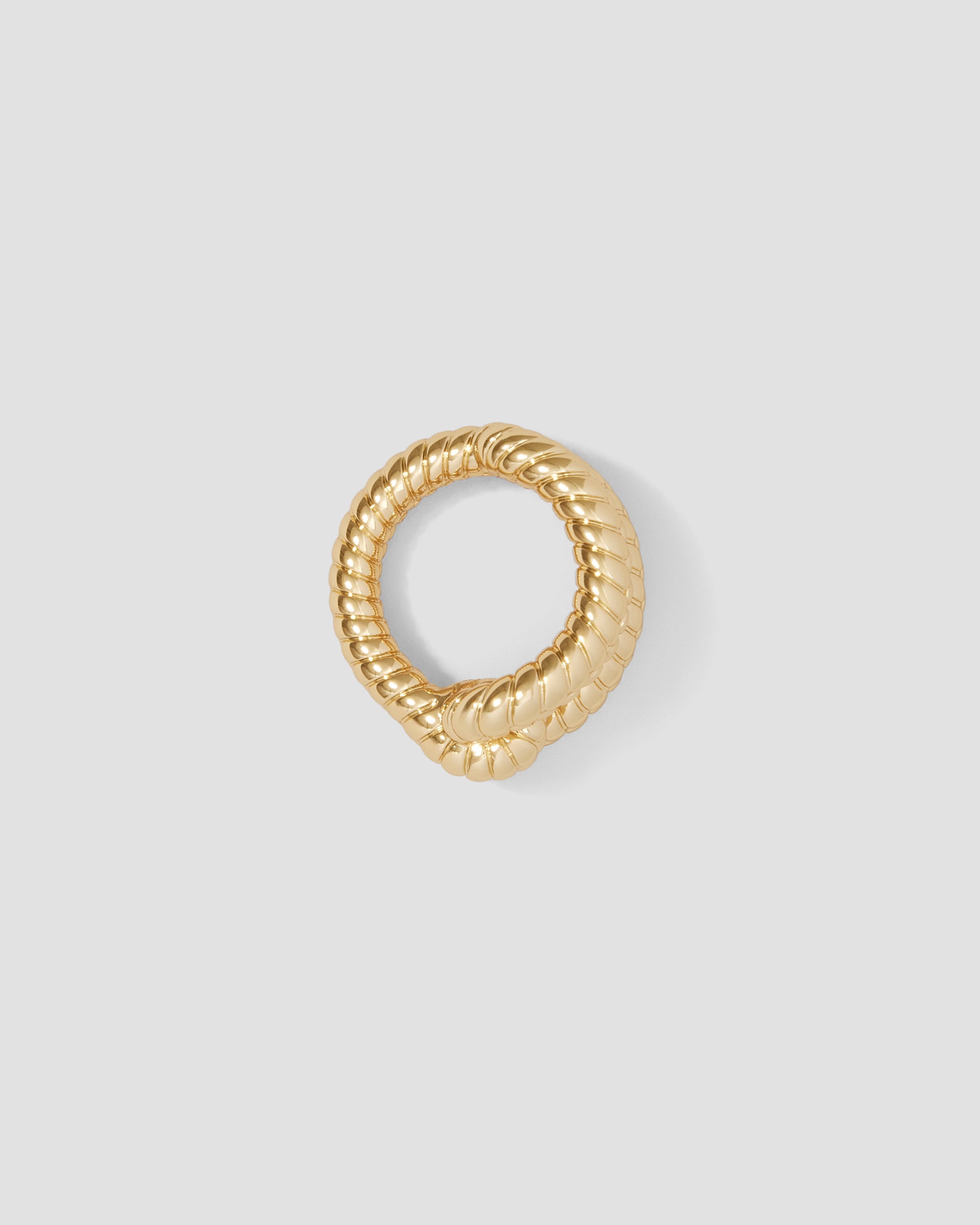 Gold ring with a textured design on a light gray background